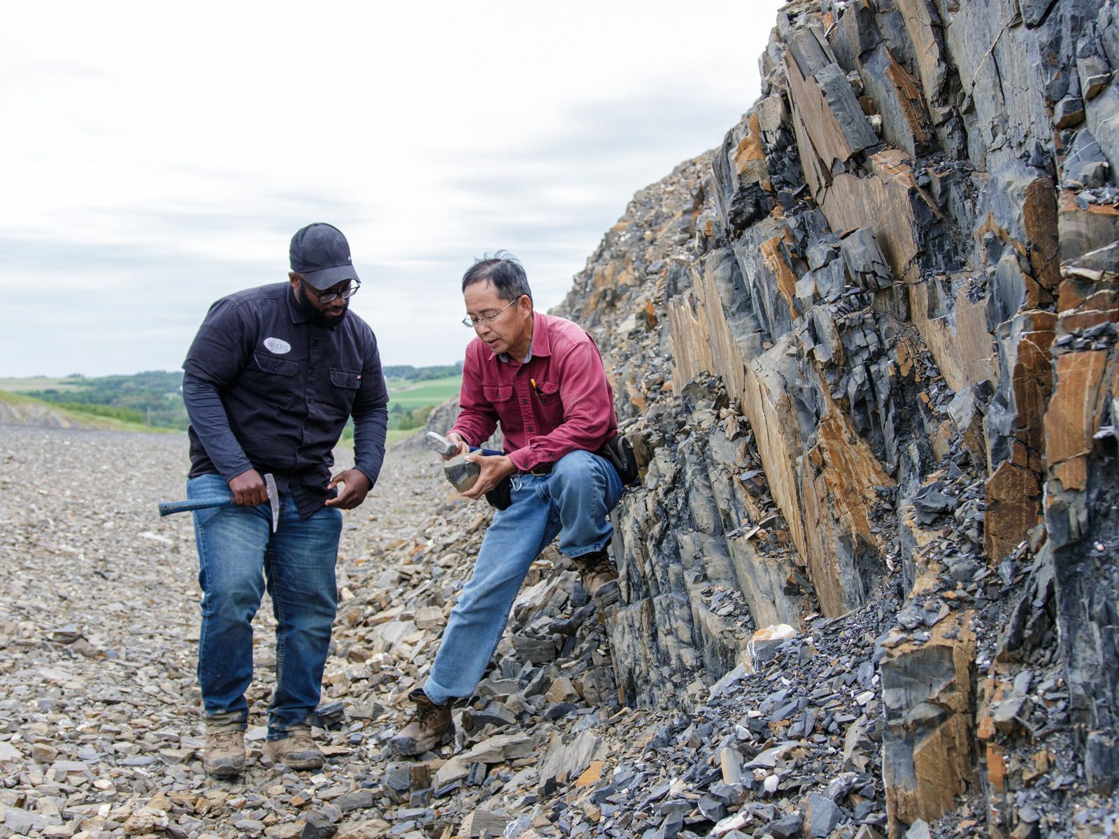 geology professor and student in the field inspecting rocks
